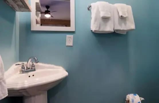 This cheerful blue bathroom with its vintage pedestal sink is basically a little spa moment every time you brush your teeth.