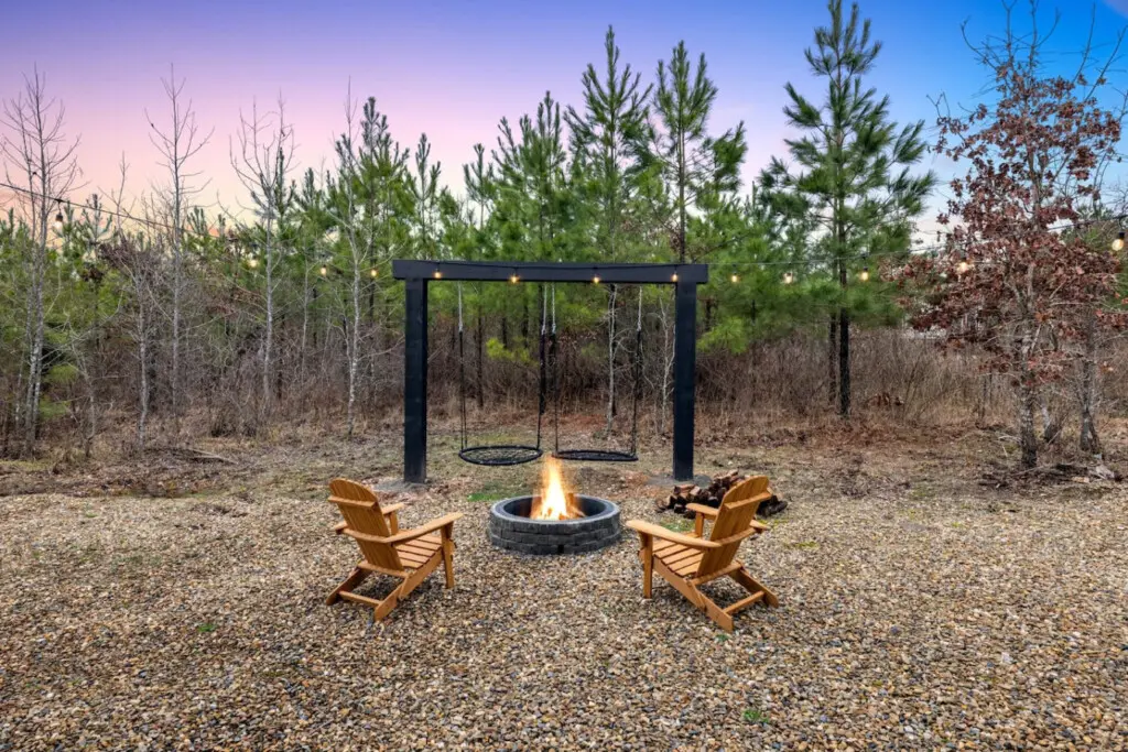 The firepit, the swings, the forest backdrop—this is the kind of setup where you actually want to stay up past midnight just to see what the night sky does.
