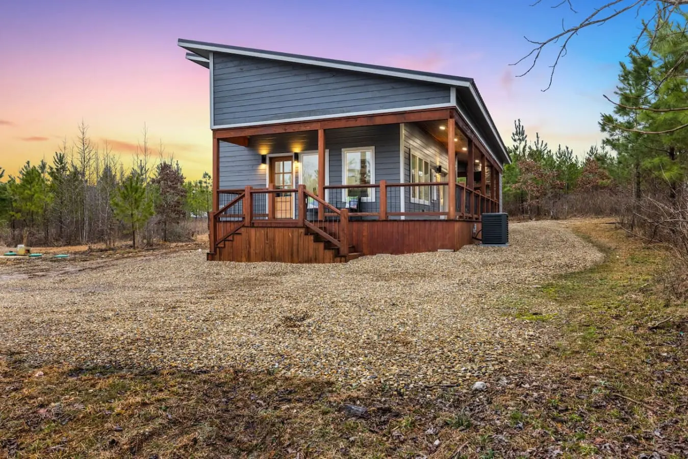 This modern cabin sits perfectly nestled in the pines with that wraparound porch that's basically begging you to slow down and actually be present for once.