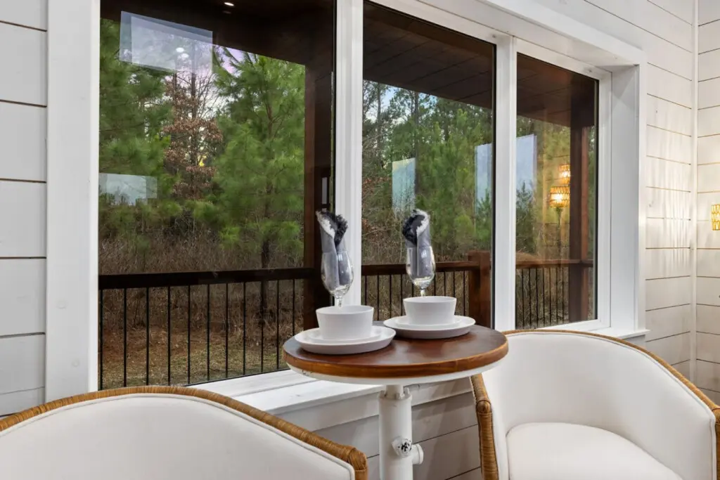 There's something about a round table set for two on a covered porch, forest views stretching infinitely beyond the glass, and the quiet understanding that this is exactly where you're supposed to be right now.