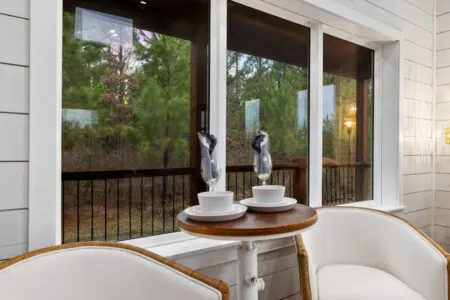 There's something about a round table set for two on a covered porch, forest views stretching infinitely beyond the glass, and the quiet understanding that this is exactly where you're supposed to be right now.