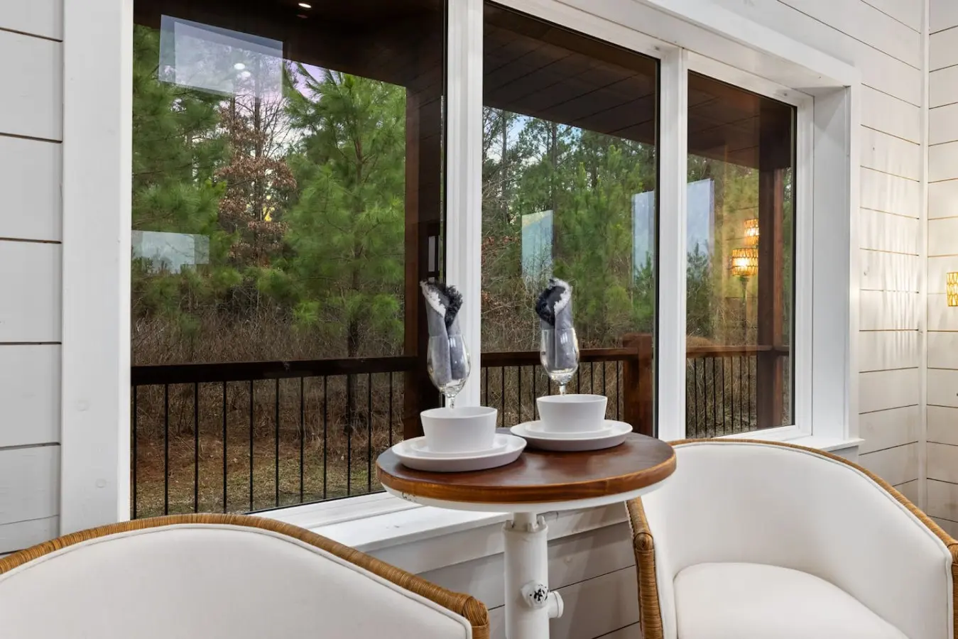 There's something about a round table set for two on a covered porch, forest views stretching infinitely beyond the glass, and the quiet understanding that this is exactly where you're supposed to be right now.