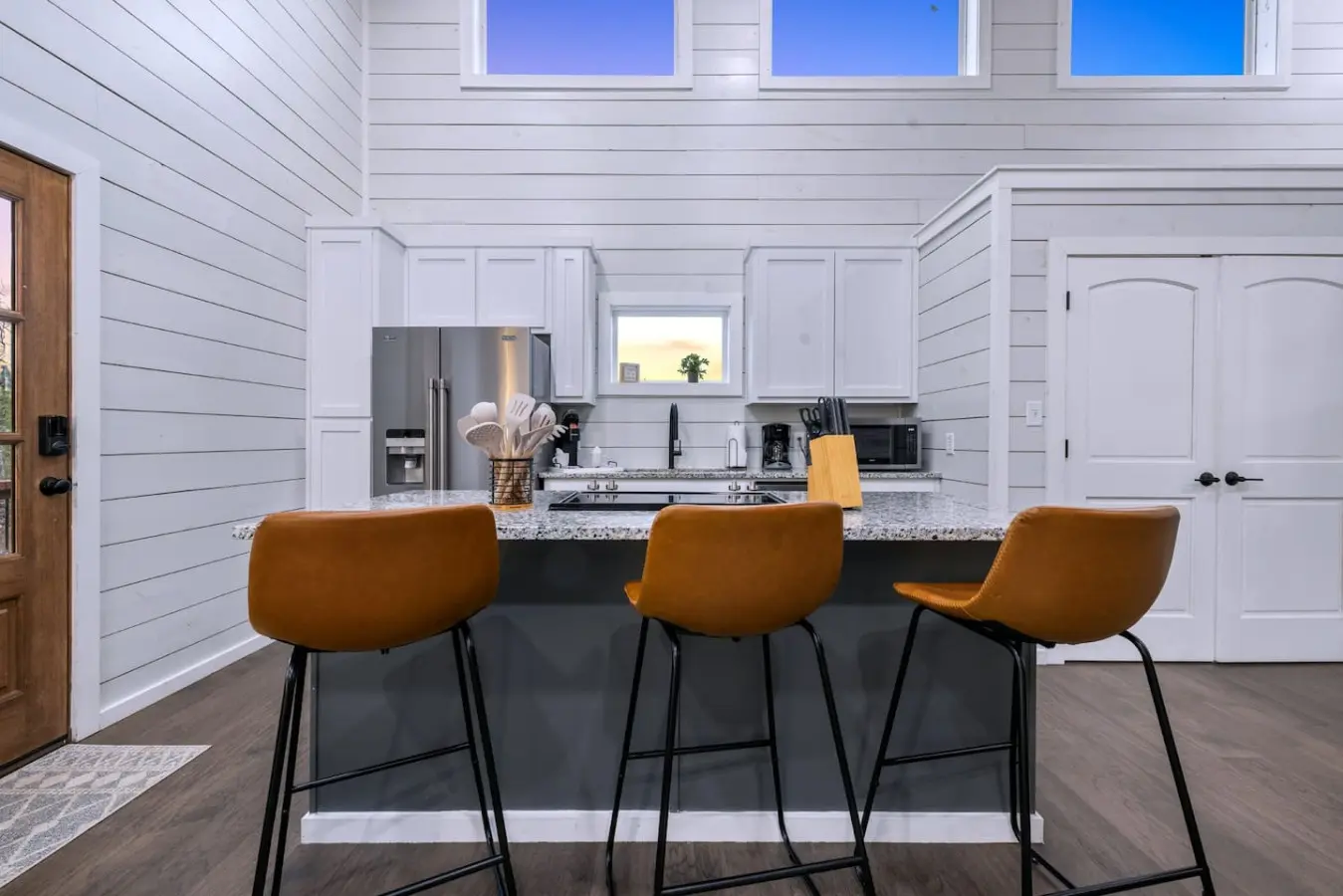 Slide onto one of those cognac-colored stools, lean against the granite countertop, and realize this kitchen island is basically the unofficial headquarters for the whole trip.