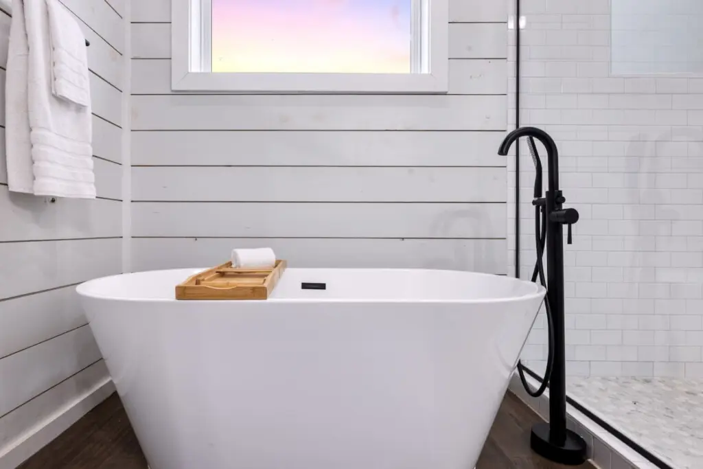 Sink into this freestanding soaking tub with the window framing that soft sky above, and you'll understand why soaking in hot water while gazing at the forest feels like the closest thing to pure peace you've ever experienced.