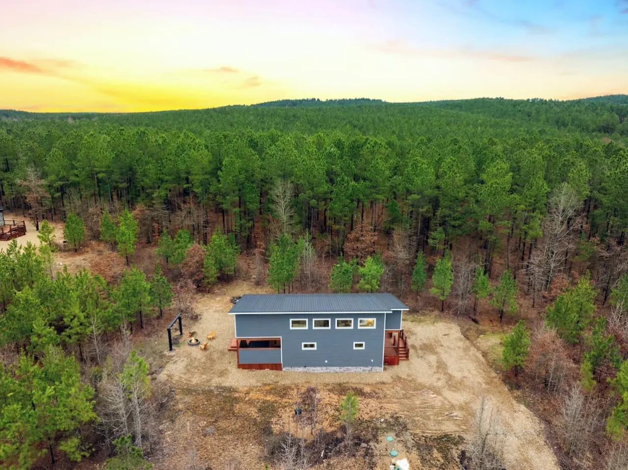 This modern cabin drops you right into the heart of a sprawling pine forest where isolation feels less like roughing it and more like you've discovered your own secret sanctuary.