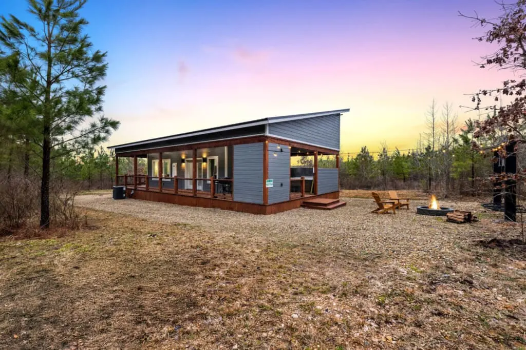 Step out onto your wraparound porch as the sun melts into the horizon and the whole forest seems to pause with you—this is the kind of magic hour that makes you understand why people talk about finding themselves in nature.
