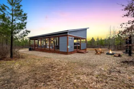 Step out onto your wraparound porch as the sun melts into the horizon and the whole forest seems to pause with you—this is the kind of magic hour that makes you understand why people talk about finding themselves in nature.