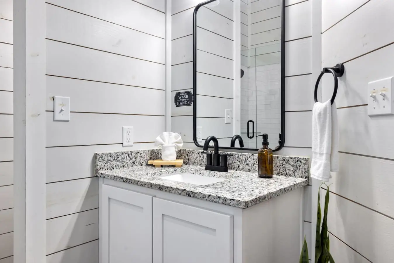 This spa-like bathroom with its clean shiplap walls, black fixtures, and that gorgeous speckled countertop is basically where you'll start every morning feeling like you've already won the day.