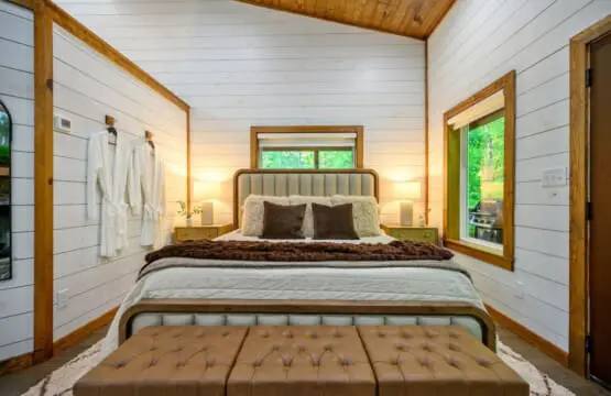 Wake up in this wood-framed bedroom with those massive windows flooding in forest views, and you'll forget that the outside world even exists.