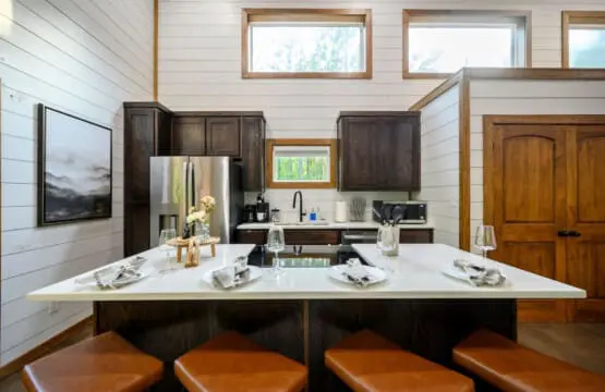 This kitchen island is basically built for lingering over morning coffee or laughing through dinner prep with your crew, thanks to those leather stools and that stunning white countertop that catches all the natural light.