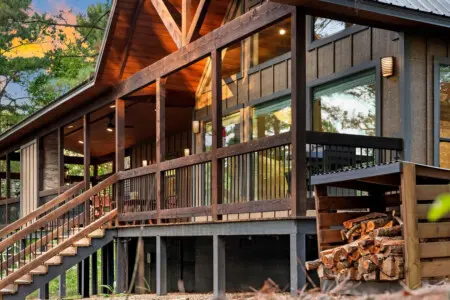 This wraparound deck with those massive timber beams and endless windows is basically your front-row seat to the whole forest, plus you've got the firewood stacked and ready whenever the mood strikes.