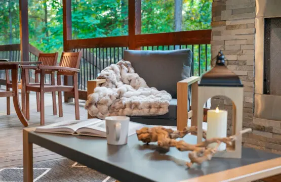 This covered porch is basically designed for those lazy afternoons where you want to lounge in a comfy chair with a blanket, flip through a book, and let the forest views and that cozy fireplace vibe do all the heavy lifting.