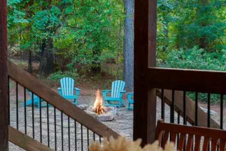 Nothing beats that moment when you step onto the deck and realize you've got front-row seats to a crackling fire, those perfect blue chairs, and a forest that goes on forever.