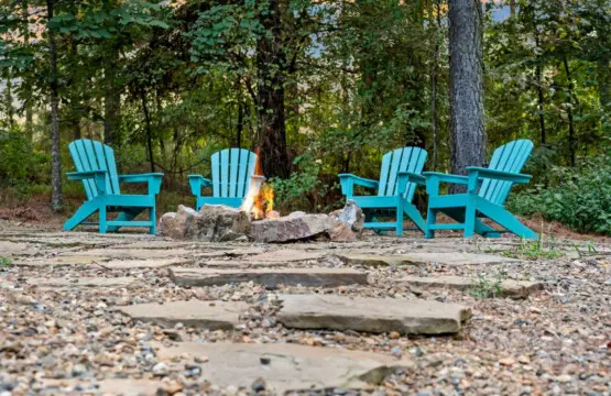 These bright blue chairs arranged around a crackling fire pit feel like the perfect invitation to pull up, stay awhile, and let the forest do all the talking.