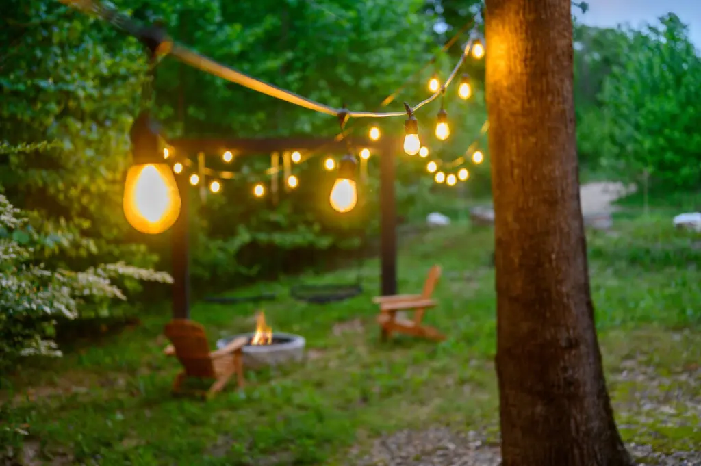 String lights are draped over the yard to provide warm lighting in the evening.