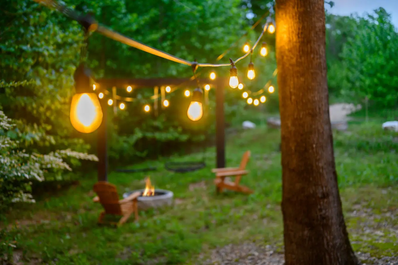 String lights are draped over the yard to provide warm lighting in the evening.