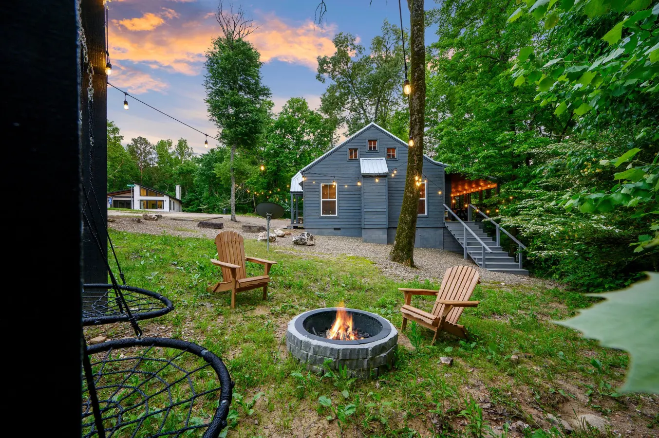 Relax in the inviting outdoor space featuring a cozy firepit and a gentle swing, perfect for unwinding under the open sky