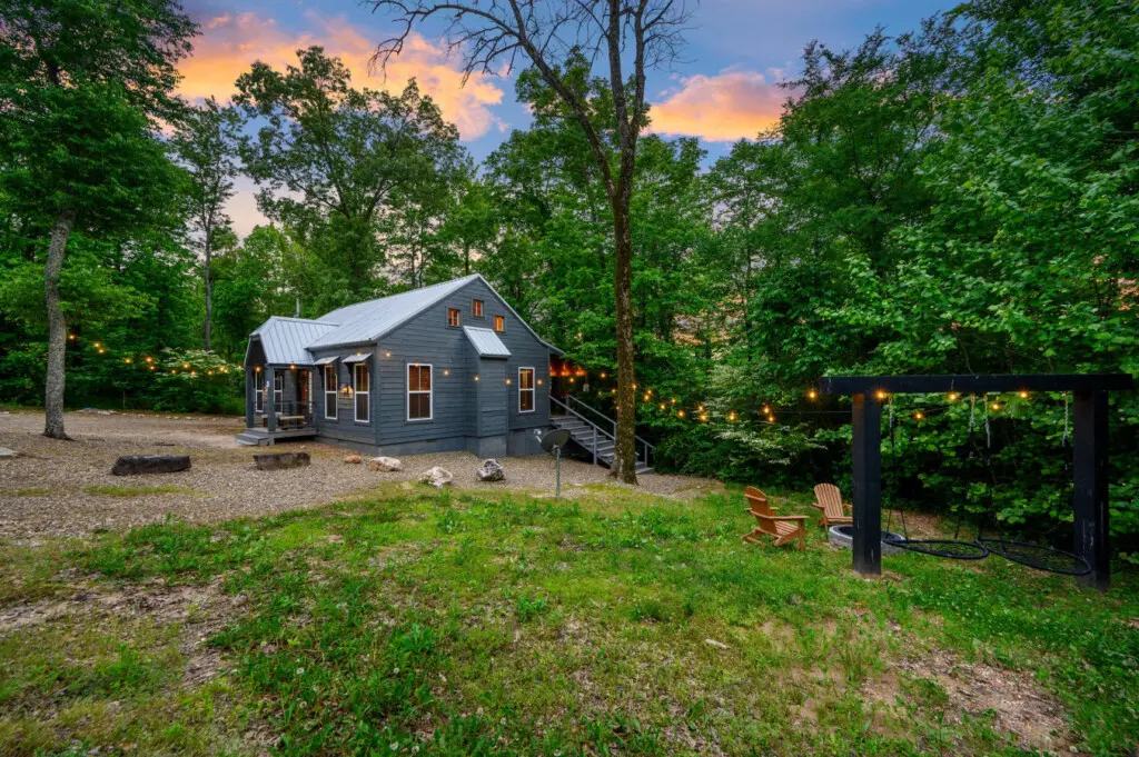 Side view of the property featuring a cozy firepit and warm string lights, creating the perfect setting for relaxing evenings outdoorsSide view of the property featuring a cozy firepit and warm string lights, creating the perfect setting for relaxing even
