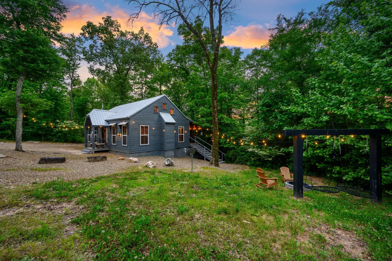 Side view of the property featuring a cozy firepit and warm string lights, creating the perfect setting for relaxing evenings outdoorsSide view of the property featuring a cozy firepit and warm string lights, creating the perfect setting for relaxing even