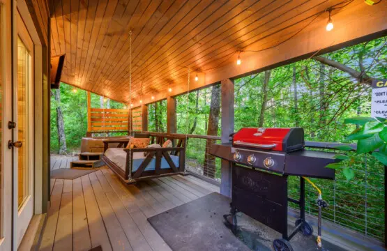Spacious deck area with a grill, perfect for enjoying outdoor cooking and dining in a relaxing setting