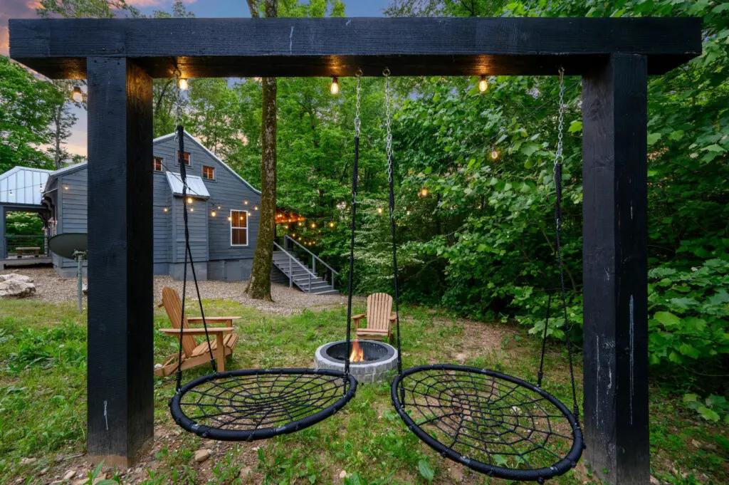 The area is arranged for relaxation, including a central fire pit surrounded by Adirondack chairs.