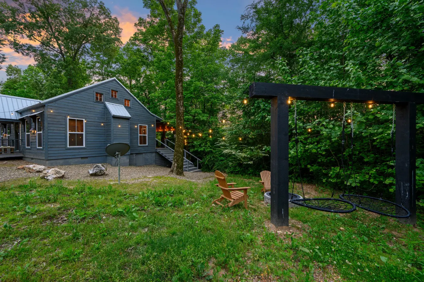 Side view of the property featuring a cozy firepit and warm string lights, creating the perfect setting for relaxing evenings outdoors
