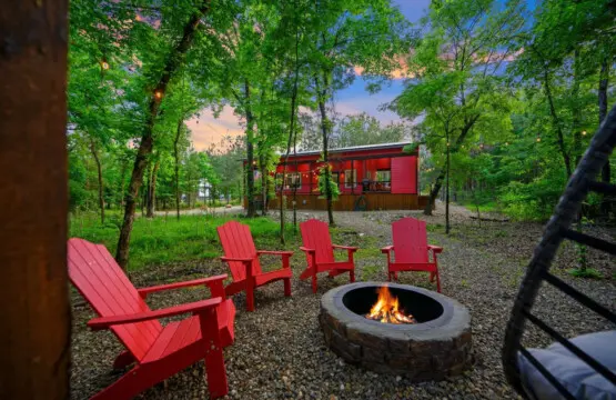 Circle up around this fire pit with those iconic red Adirondacks, and you'll realize this is exactly the kind of spot where conversations stretch into the night and nobody's checking their phones.