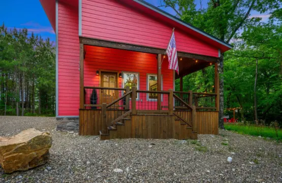 Welcome to Lil Red—this bold little cabin with its striking red exterior and welcoming front porch is basically the forest's way of saying "come sit a while," and honestly, the vibe hits you the second you pull up.