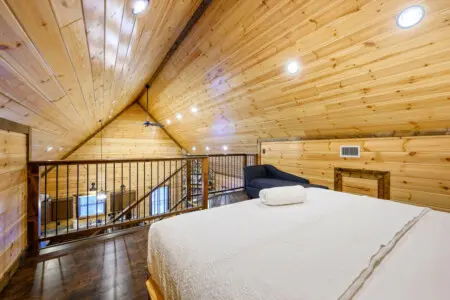 This gorgeous loft bedroom features soaring wood ceilings, recessed lighting, and a cozy mezzanine perfect for extra guests.