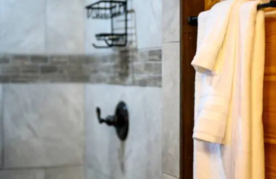 The shower features sleek tile work, a rainfall showerhead, and built-in shelving for all your essentials.