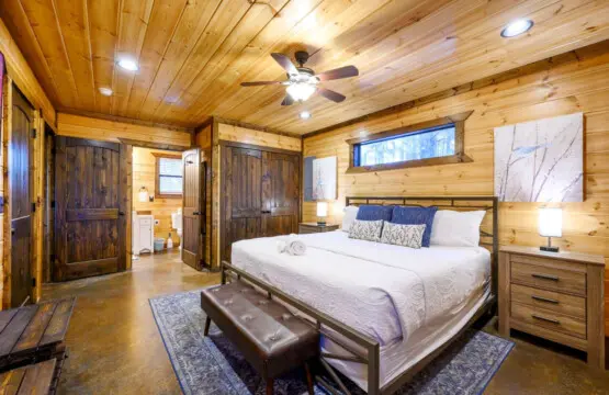 This gorgeous log cabin bedroom feels like a cozy retreat with plenty of natural wood and modern comforts.