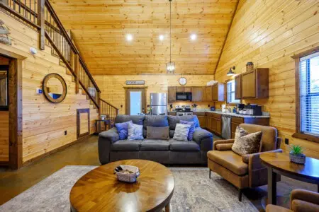 This open-concept cabin brings together rustic charm with modern comfort, featuring exposed wood beams and a fully equipped kitchen.