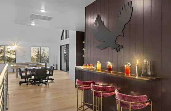 Bar area with eagle wall art and velvet stools — ready for whatever the evening brings.