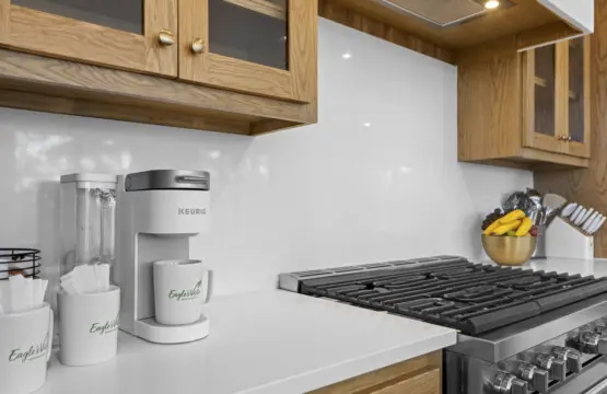 Morning coffee setup is ready to go with a Keurig and branded mugs right next to the gas range.