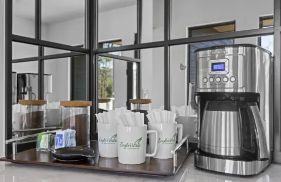 The coffee station's got branded mugs, fresh filters, and what looks like two kinds of ground coffee ready to go.