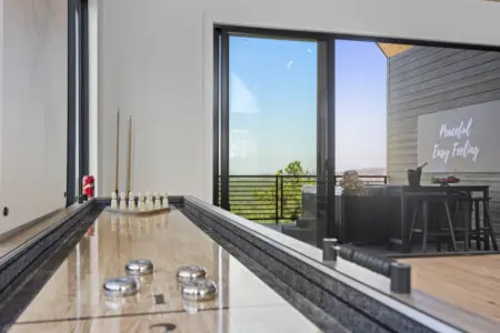 Shuffleboard and bowling pins set up with a view of the deck — game room hangs at Eagle's Vista don't disappoint.