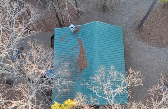 Cute turquoise storage shed nestled among the desert brush with a view from above.
