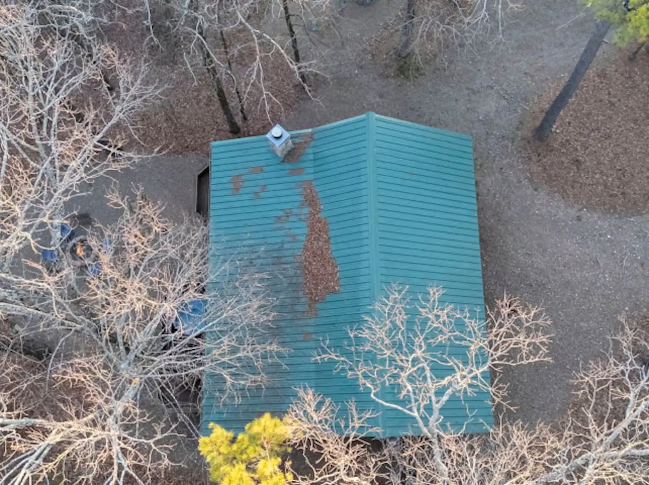 Cute turquoise storage shed nestled among the desert brush with a view from above.