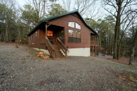 Cozy log cabin nestled in the woods with a spacious deck and plenty of natural light.
