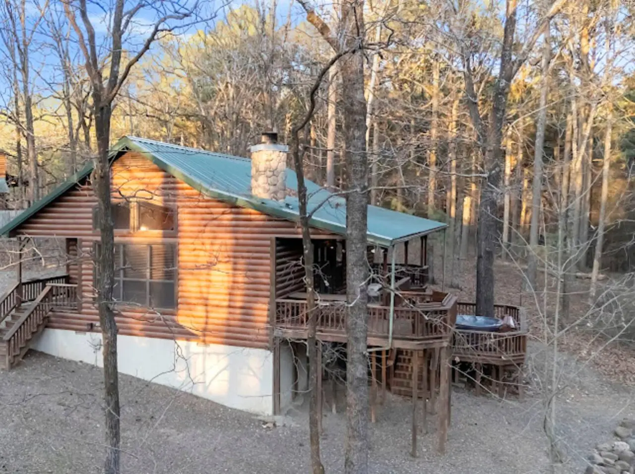 Cozy log cabin nestled in the woods with multiple decks and that perfect forest getaway vibe.