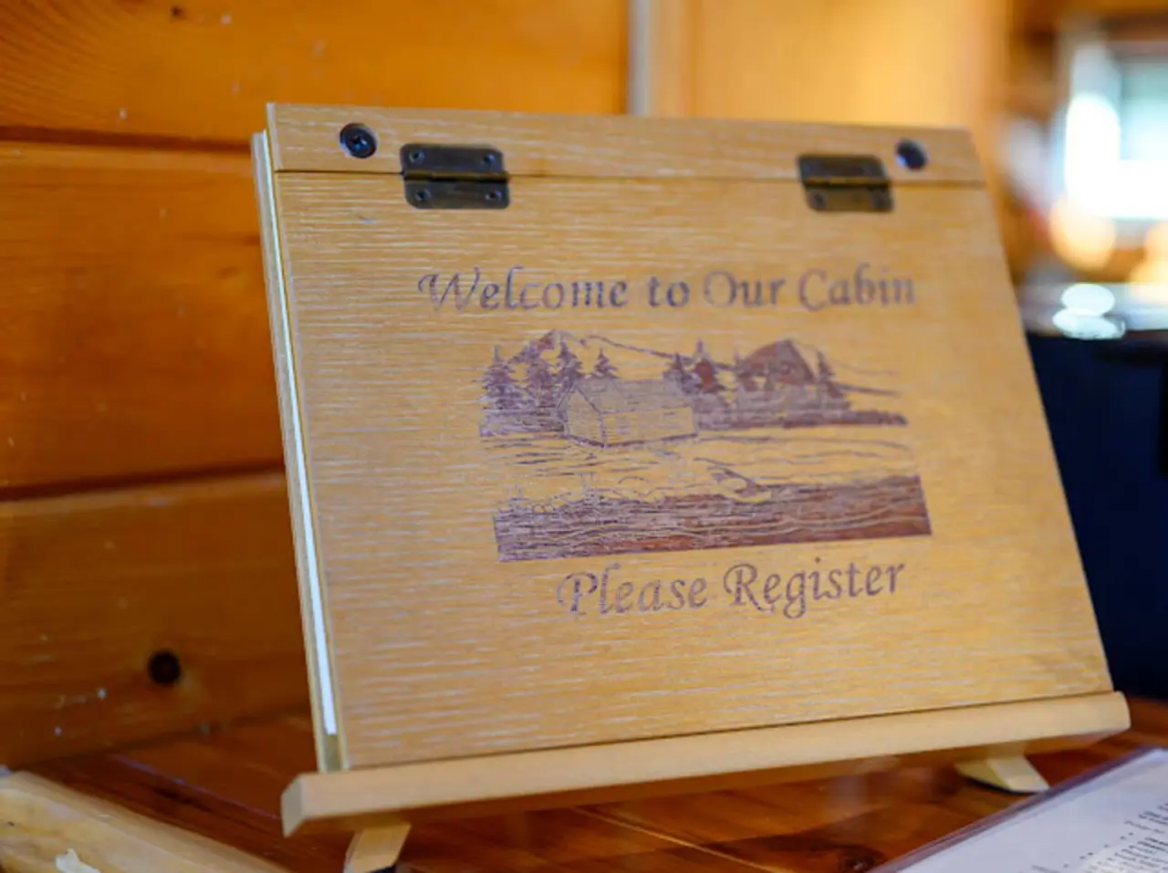 This beautiful wooden guest book welcomes visitors to the cabin with engraved mountain and forest scenery.