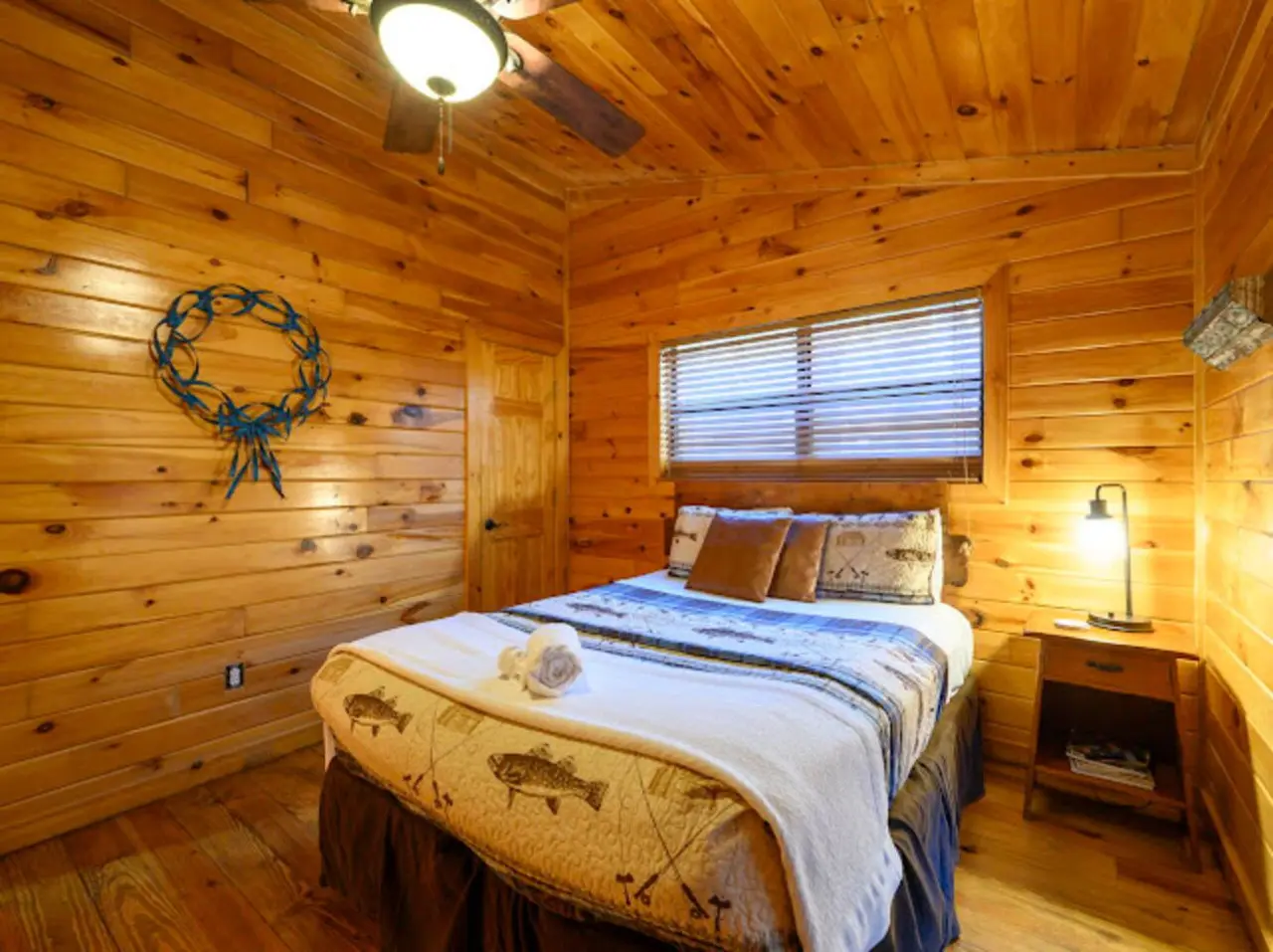 Cozy wood cabin bedroom with a queen bed, plenty of natural light, and rustic lodge charm throughout.