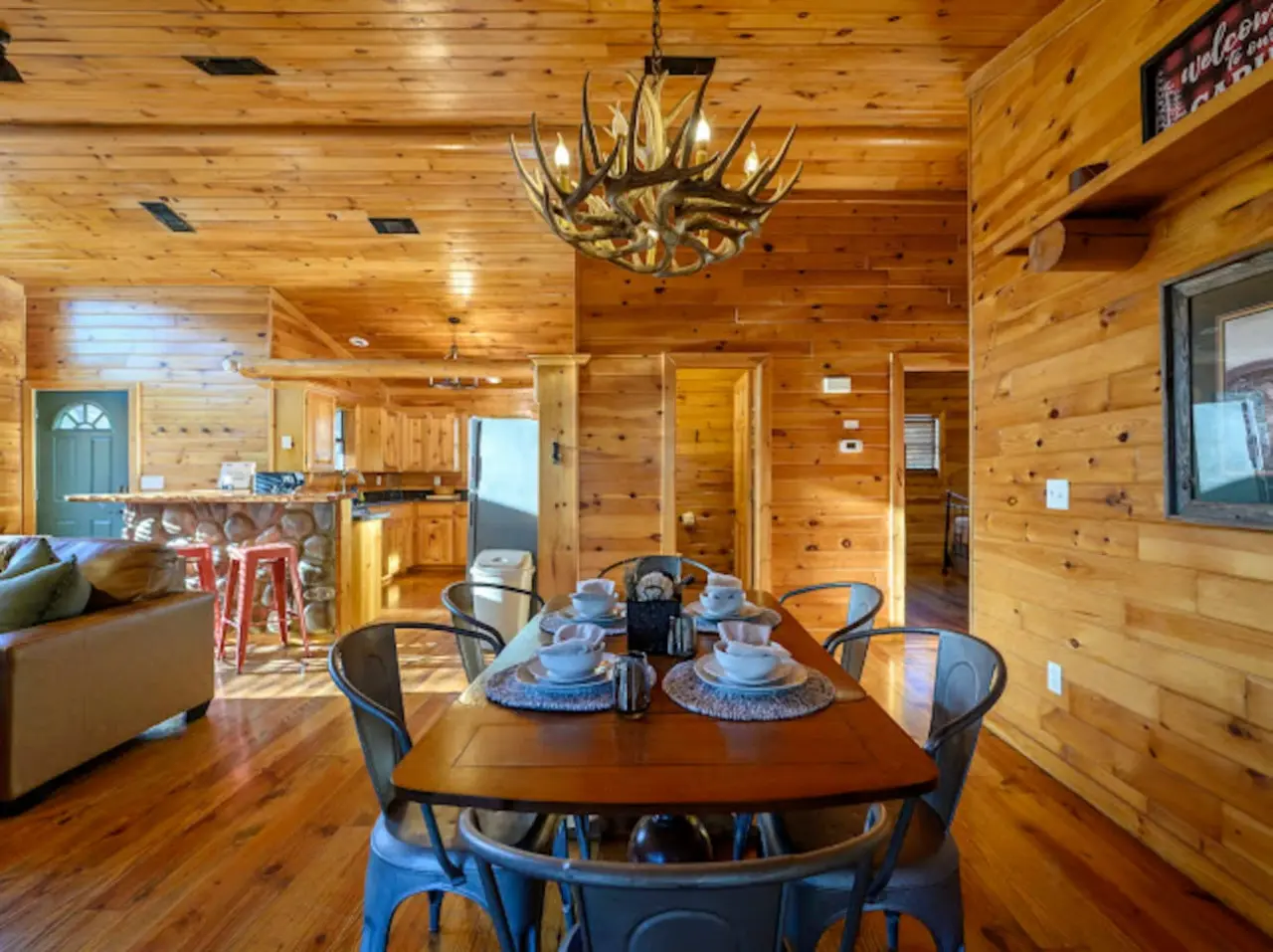 This cozy log cabin dining area flows seamlessly into the kitchen and living spaces with beautiful wood throughout.