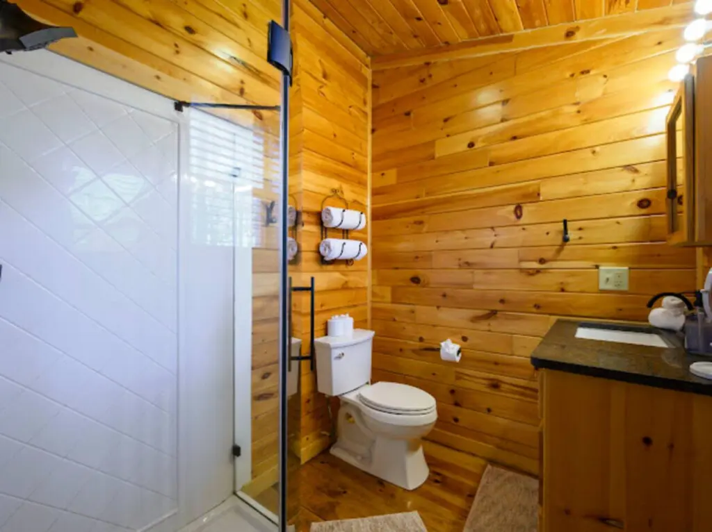 This cozy log cabin bathroom features a spacious walk-in shower and rustic wood finishes throughout.