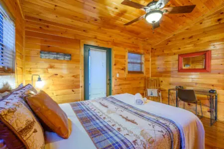 This cozy wood cabin bedroom has everything you need for a peaceful getaway with a comfy bed and plenty of natural light.