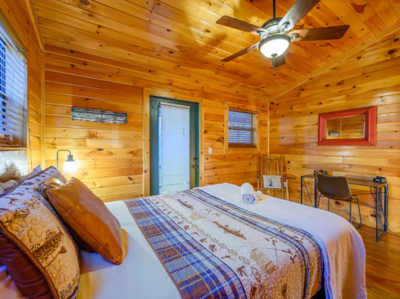 This cozy wood cabin bedroom has everything you need for a peaceful getaway with a comfy bed and plenty of natural light.