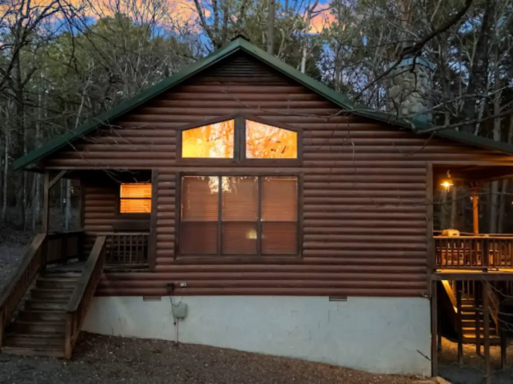 Cozy log cabin nestled in the woods with warm lighting and a peaceful forest setting perfect for a getaway.