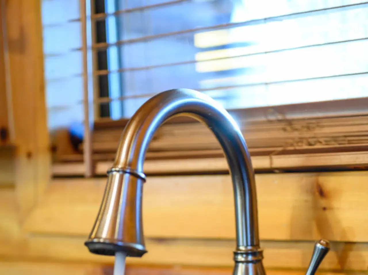 This modern kitchen sink has a sleek pulldown faucet with killer water views through the window.
