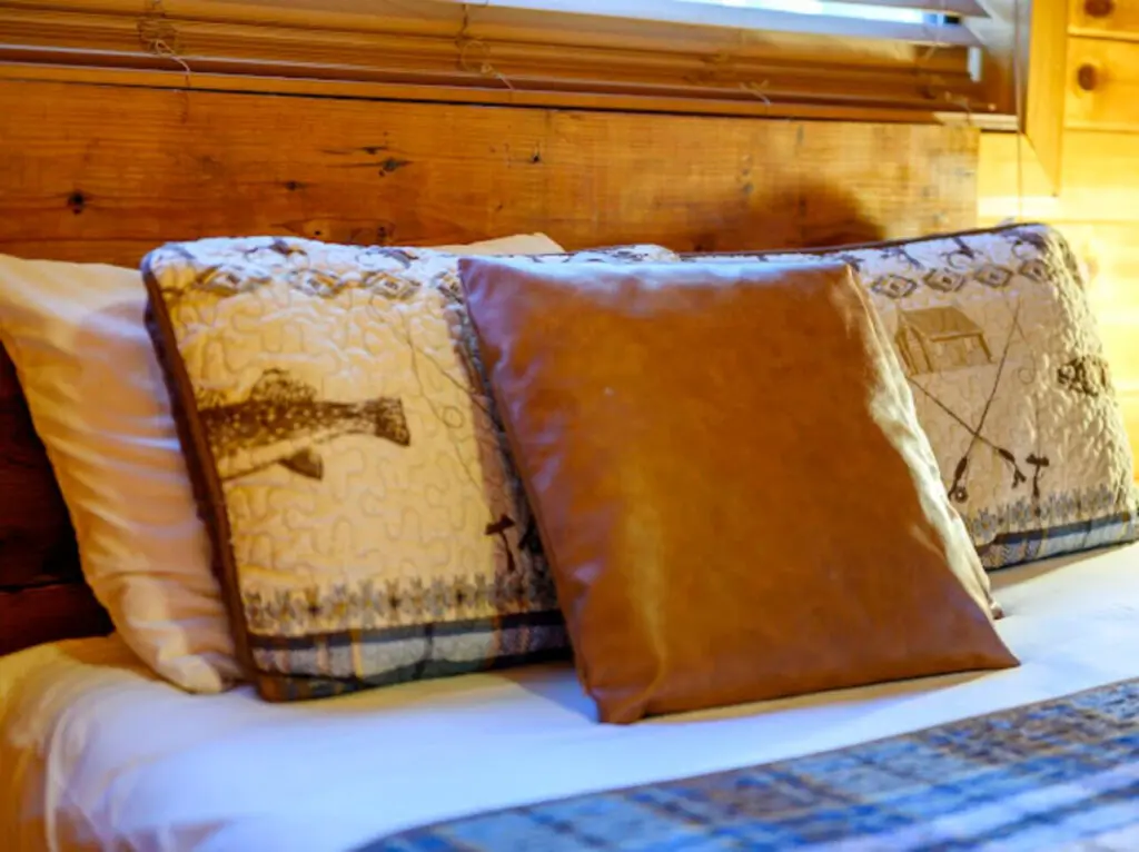 Cozy log cabin bedroom with plush pillows and natural wood beams creating that perfect mountain retreat vibe.