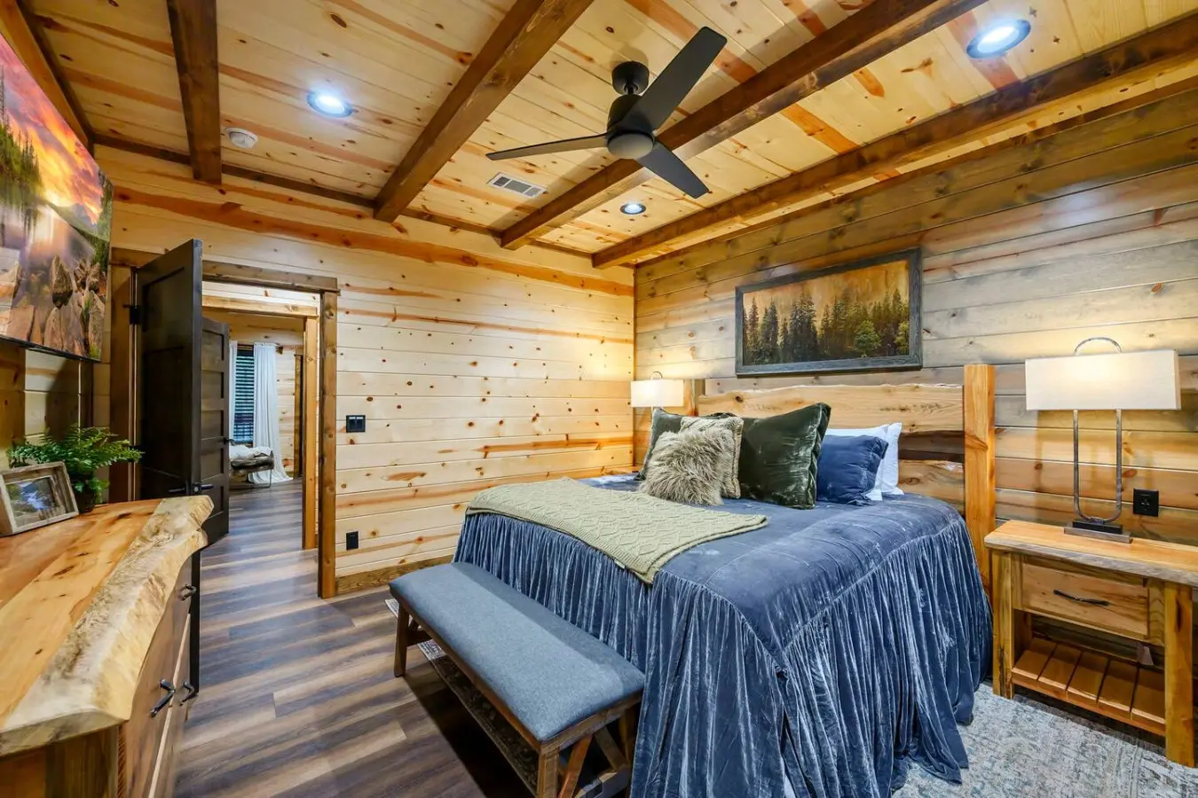 This cozy log cabin bedroom features exposed beam ceilings, a plush king bed, and rustic wood finishes throughout.